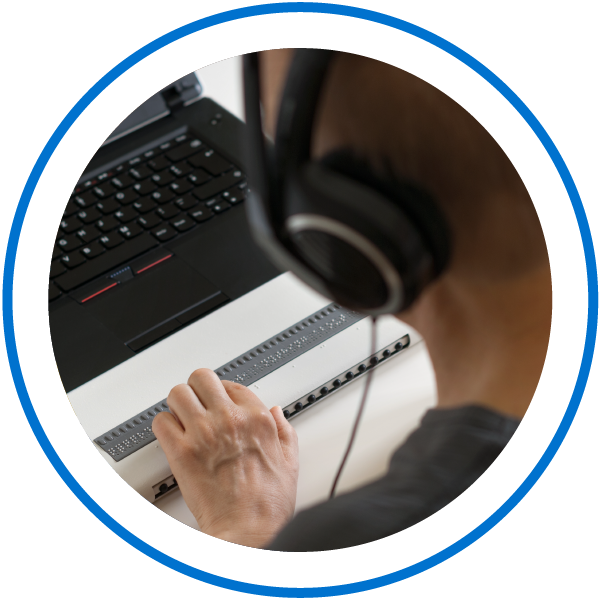 a person using a braille computer keyboard wearing headphones