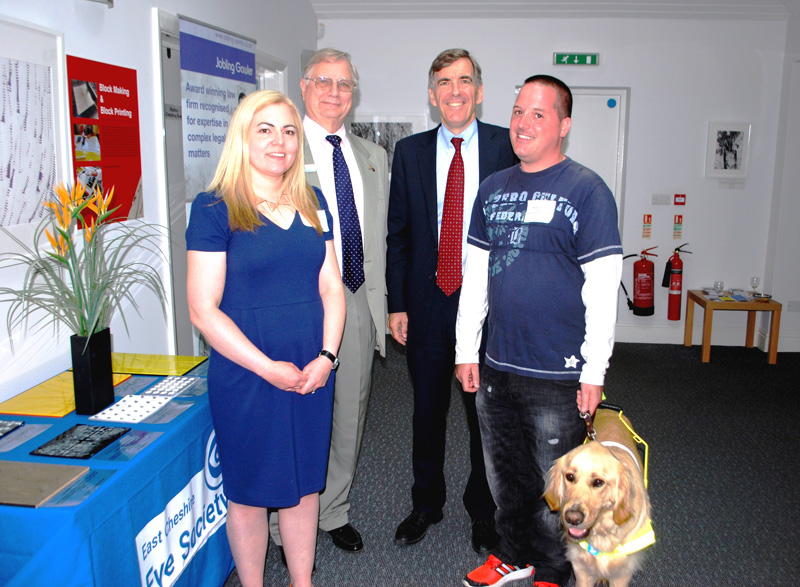 Francesca, Ray,  David Rutley (Local MP) and Mark with his guide dog, discussing the exhibition